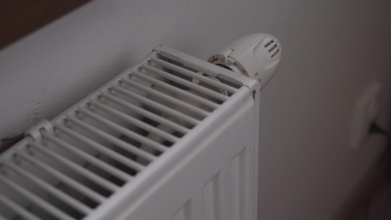 난방 또는 라디에이터 온도 조절기를 켜고, 손으로 클로즈업, 완전한 전력, 돈을 비합니다.