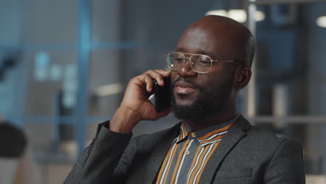 Afroamerikanischer-Geschäftsmann,-Der-Nachts-Im-Büro-Telefoniert