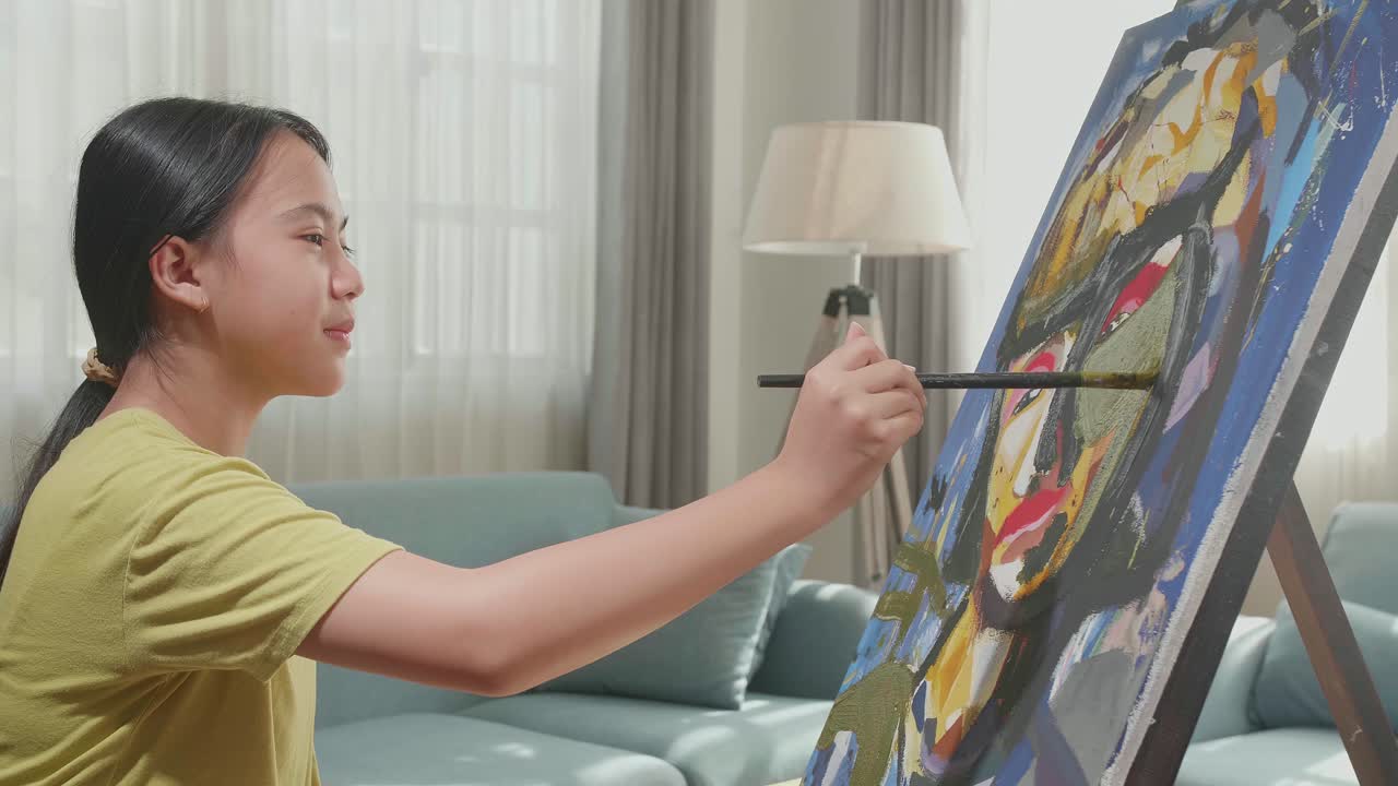 Side View An Asian Artist Girl Holding Paintbrush Mixed Colour Turn To Cross His Arms And Smile While Painting A Girl On The Canvas