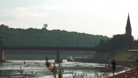 toma estática de globo aerostático, torre de la iglesia y puente mientras brilla el sol
