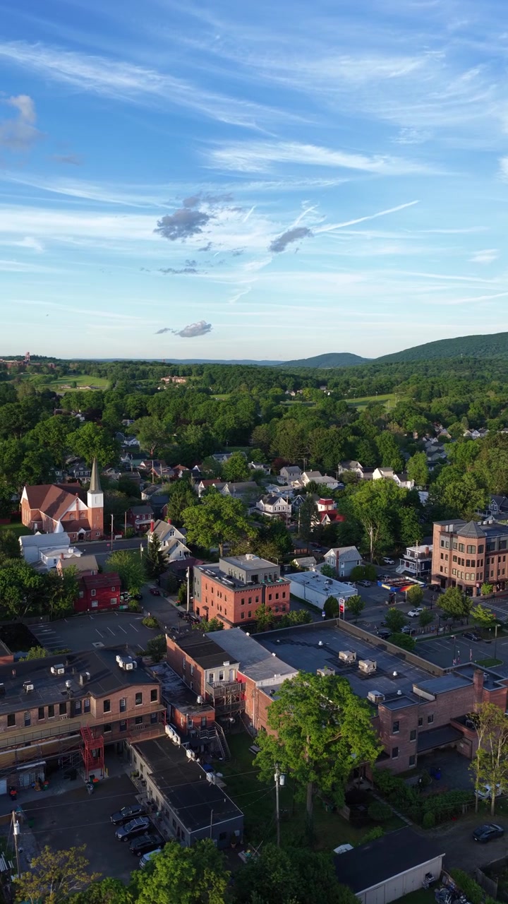 Una vista aerea al tramonto di Beacon, New York, che mostra sia l'area del centro di Main Street che i quartieri residenziali. Le montagne degli Hudson Highlands sono mostrate nella pittoresca città della Hudson Valley