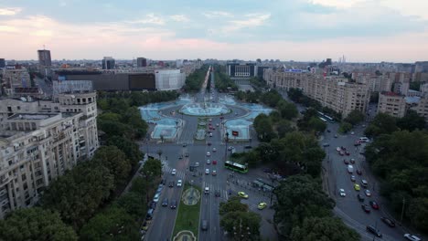 cinematic aerial view of unirii square at dusk, bucharest, romania: the famous water fountains in the middle of the frame