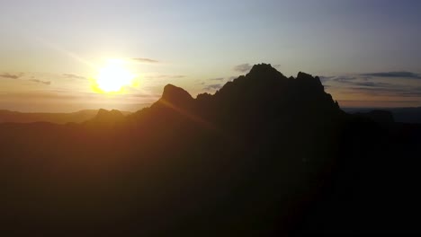 Vuelo-Lento-A-La-Cima-De-Los-Pináculos-De-Las-Montañas-Coromandel-En-Silueta-Al-Amanecer