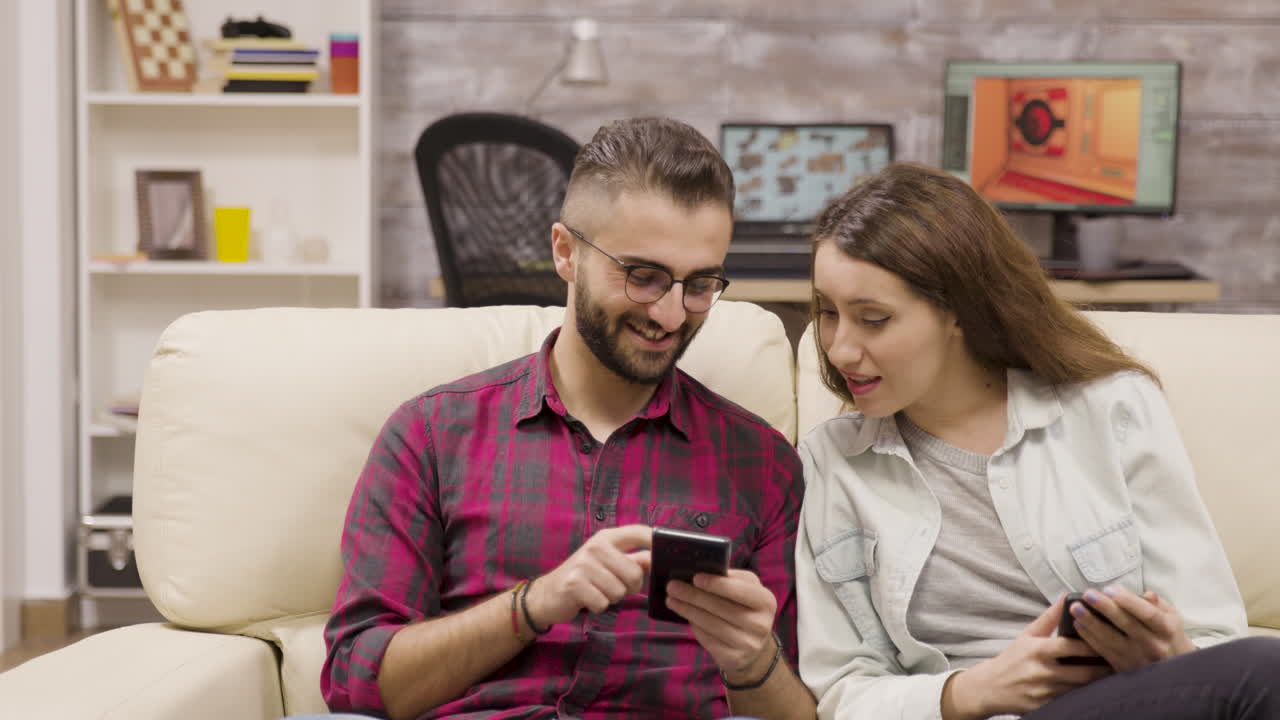 Couple using smartphones sitting on a couch