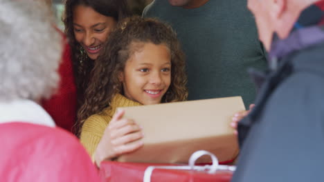 grandparents arriving with gifts to celebrate multi-generation family christmas at home