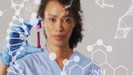 animation of dna strand and shapes over biracial female doctor with test tube