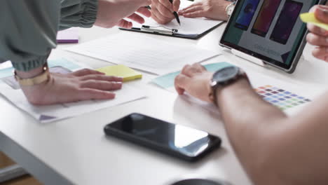 Group-of-people-discussing-over-color-options-and-design-layouts-on-a-business-table