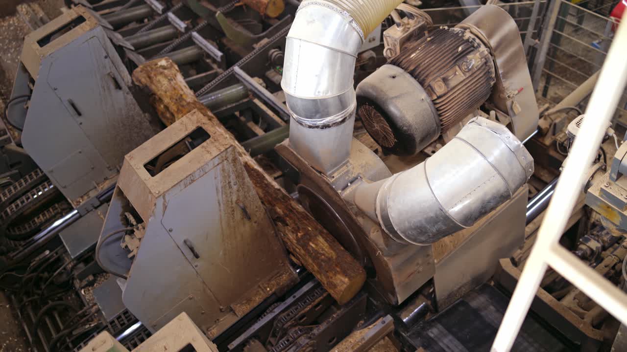 Forest product industries. Sawmill. Process of machining logs in a machine, Heavy industry equipment. Closeup. view from the top. Wood industry facilities.