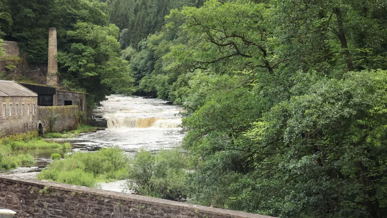 Wide angle shot of a small waterfall at New Lanark