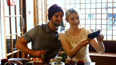 couple talking and taking a selfie on mobile phone