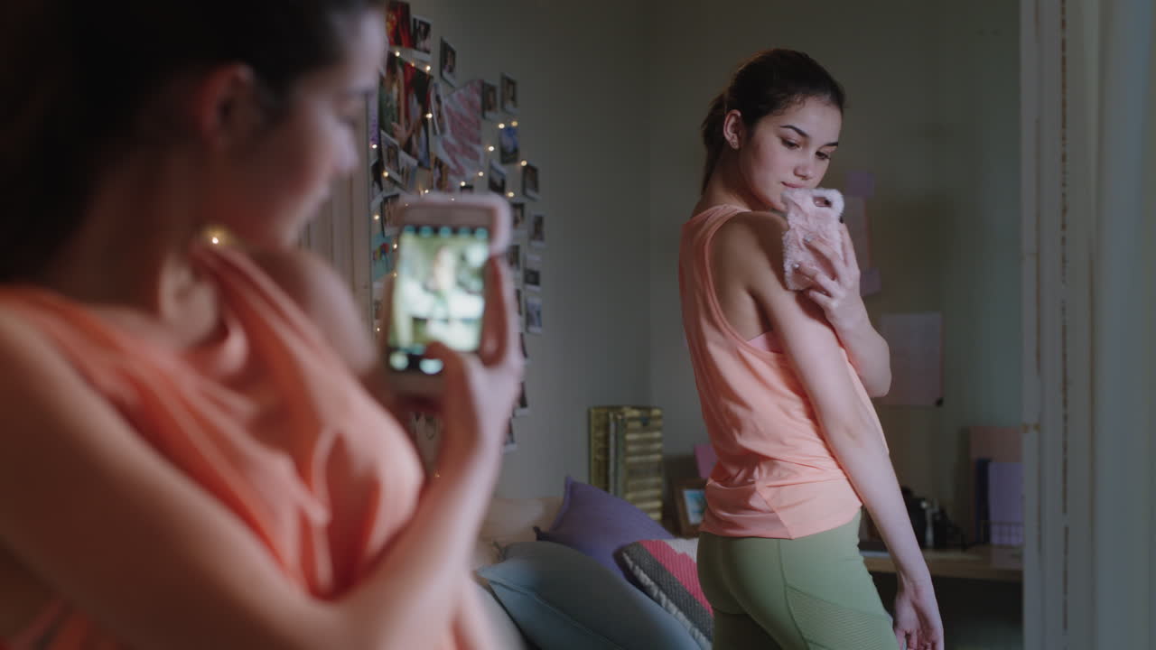 ragazza adolescente felice che si fa una selfie usando lo smartphone che posa allo specchio che condivide la moda elegante sui social media che si gode il fine settimana a casa immagine di sé adolescente
