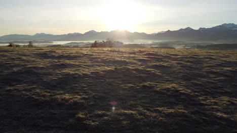 Flying-above-Meadow-in-Bavarian-Alps-during-Sunrise,-side-movement