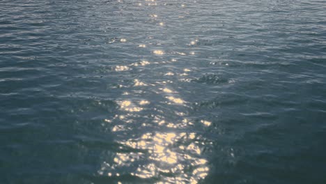 Primer-Plano-Del-Reflejo-De-La-Luz-Del-Sol-En-El-Agua-Del-Mar-Con-Ondas.