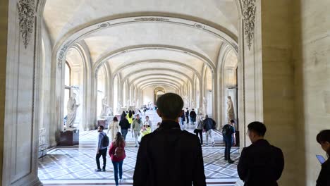 people exploring the louvre museum's grand hallway