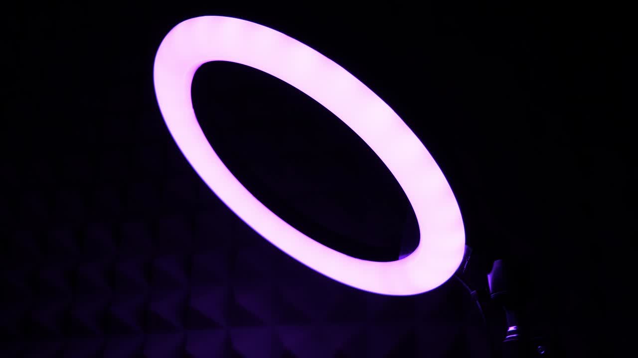 Luminous ring rgb lamp. Multicolored light in a dark room, close-up.