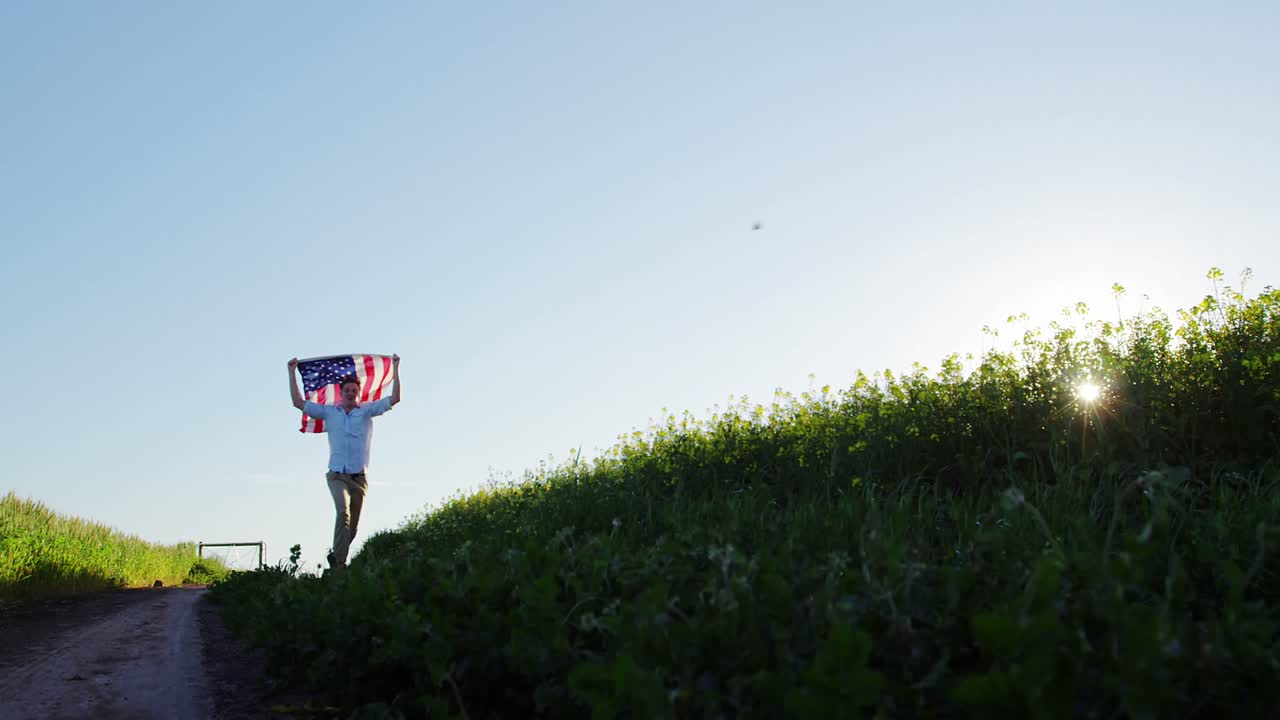 Uomo che tiene una bandiera americana e corre in un campo