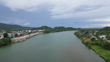 Aerial-View-of-Wide,-Tropical-River-landscape-in-between-Rural-Barangay-Villages-with-stunning-cloudscape-in-Catanduanes,-Philippines