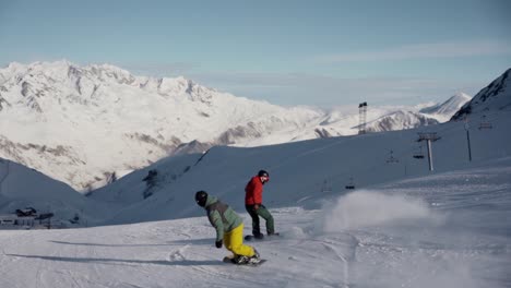 People-snowboarding-down-the-slope-in-the-mountains-during-winter