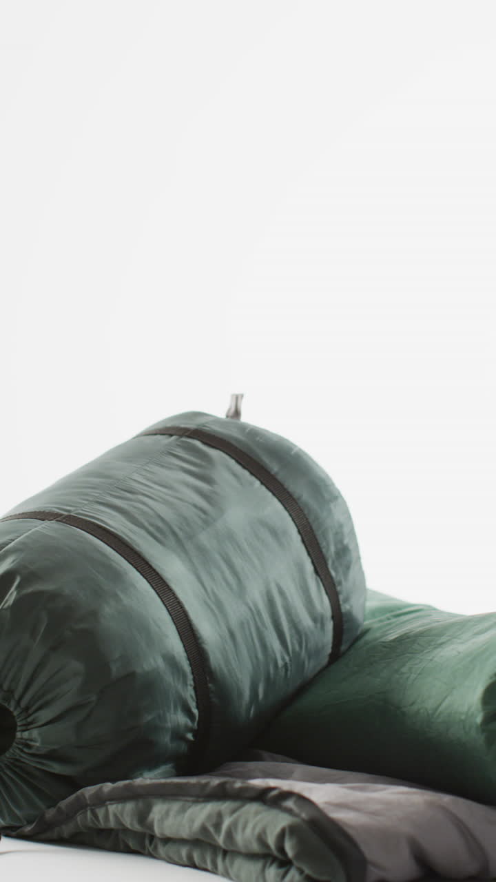 video vertical de equipos de campamento con sacos de dormir y espacio de copia sobre fondo blanco