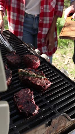 amigos asando filetes en la parrilla