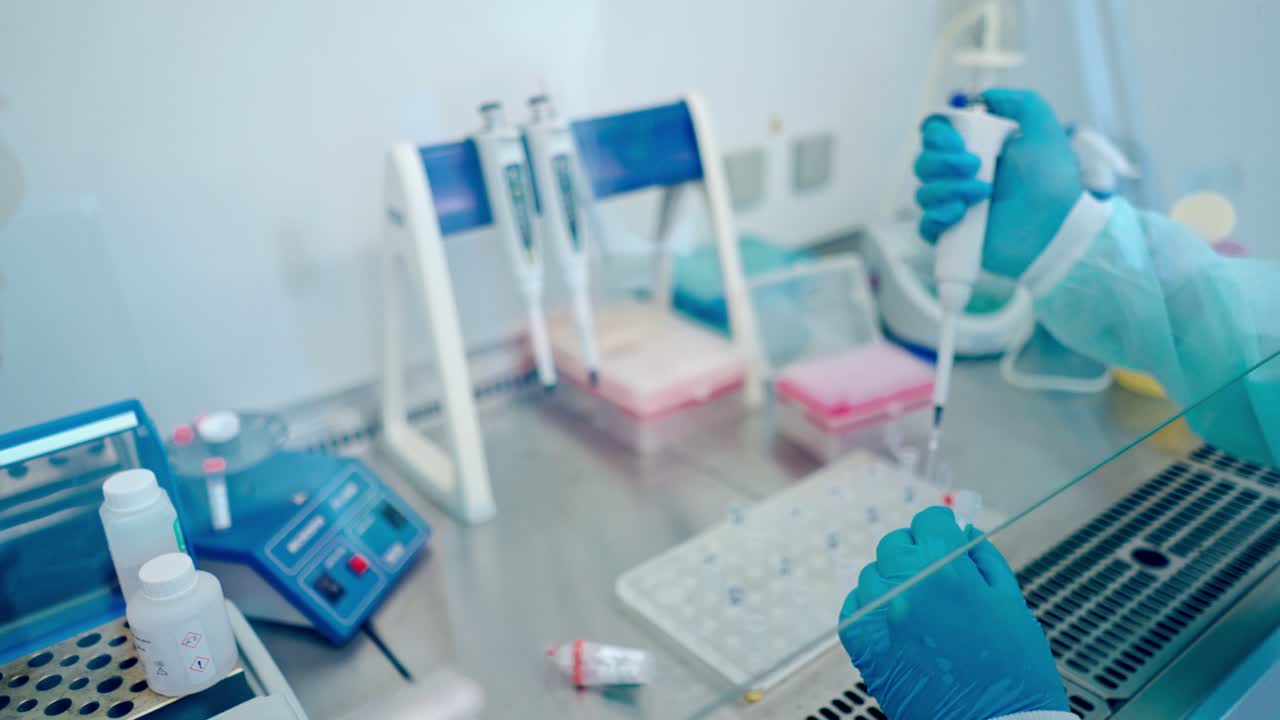 Scientist in Innovative Pharmaceutical Laboratory. Close up of the hand in gloves using micro pipette while working with test tubes