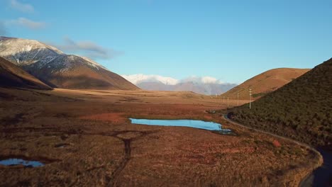 Drone-aerial-tracking-through-mountains-with-lakes-and-snow