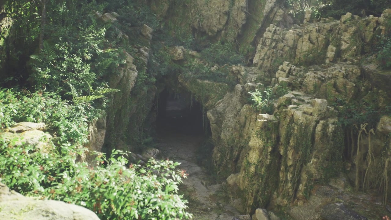 Quiet cavern opening surrounded by vibrant greenery and rugged formations