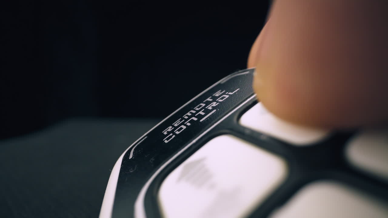 persona presiona la tecla en el control remoto negro del juguete automático