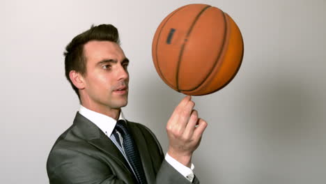 hombre de negocios girando el baloncesto en el dedo