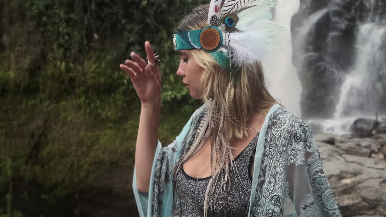 mujer en un traje boho junto a una cascada