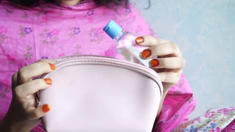 woman holding a travel makeup bag with hand sanitizer