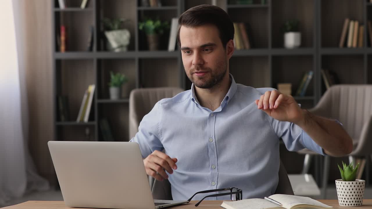 hombre terminado el trabajo de la computadora se quita las gafas apoyarse en la silla