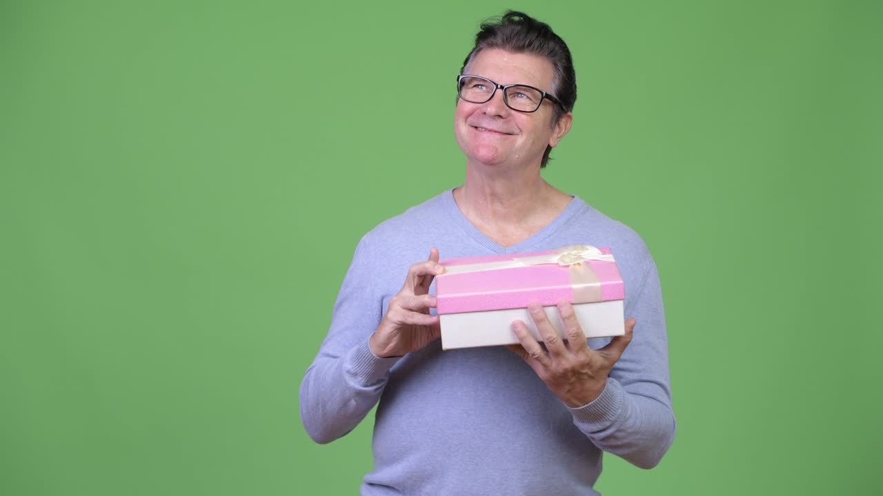 Senior handsome man opening gift box