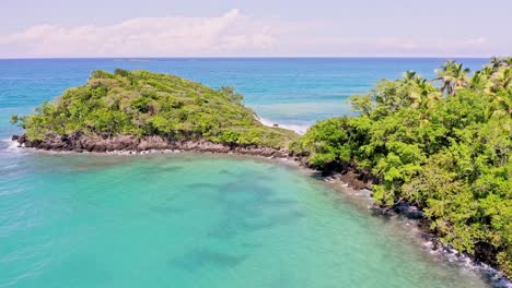 slow aerial flight showing tropical island with trees and clear water of caribbean sea during sunny day - playa bonita,las terrenas