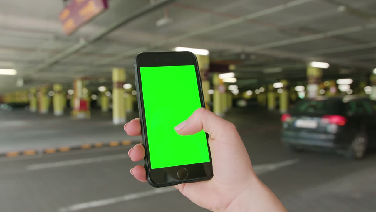 una mano sosteniendo un teléfono con una pantalla verde