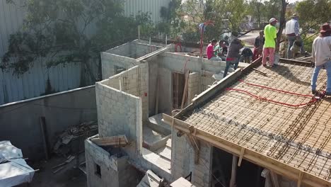 construction workers manually pouring reinforced concrete slabs for a housing complex in the metropolitan area of mexico city