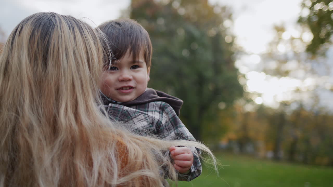 Mutter und Sohn spazieren im Herbstpark.