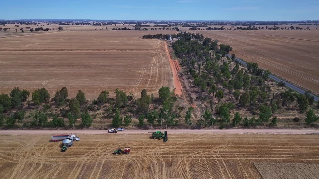 retiro y descenso sobre un paddock de trigo con equipos de cosecha más allá
