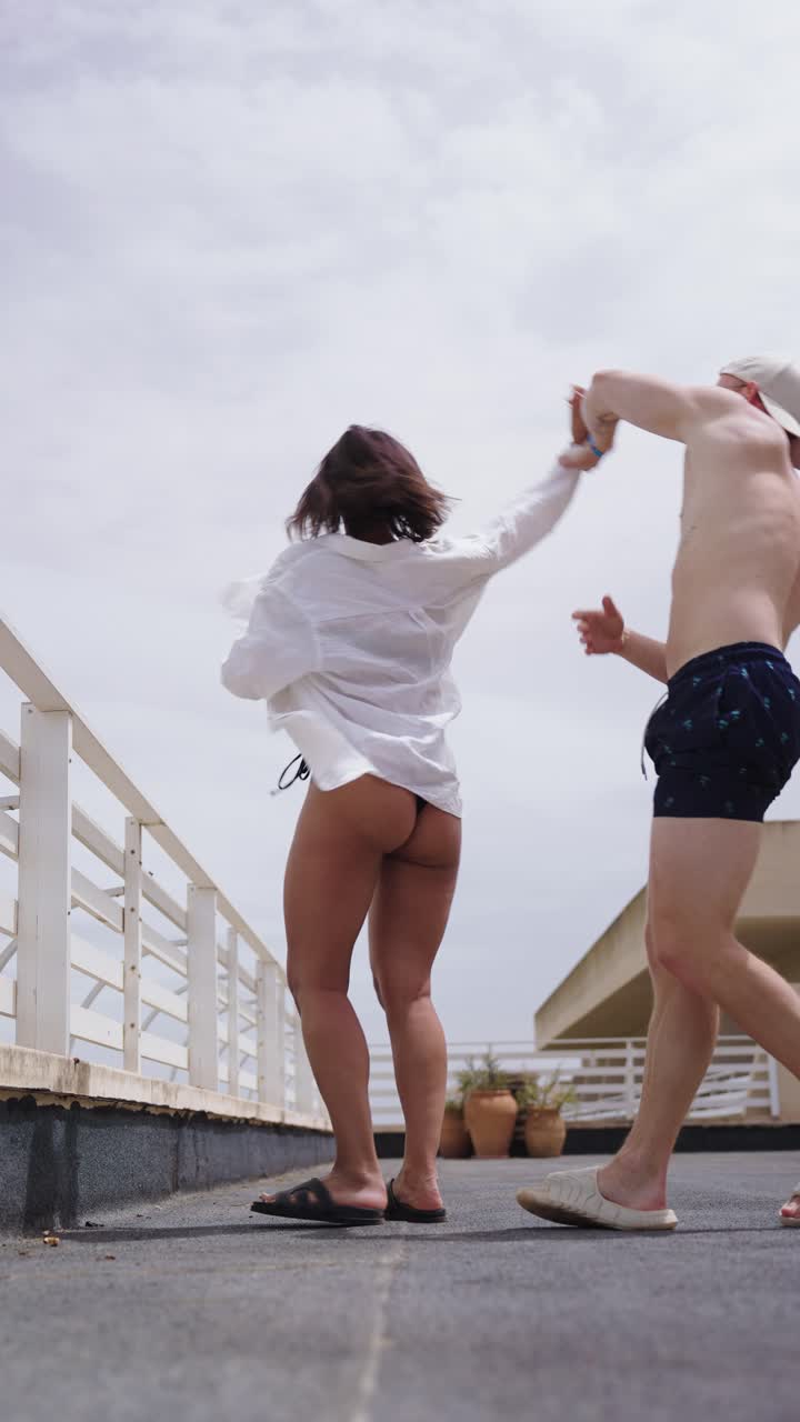 Vertical view of happy and cheerful couple dance on hotel balcony, Mallorca