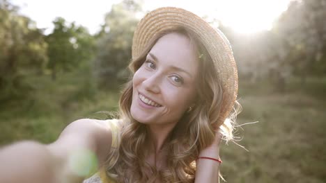 Hermosa-Mujer-Rubia-Con-Sombrero-De-Paja-Haciendo-Selfie,-Posando-Para-La-Cámara,-Enviando-Un-Beso-Al-Aire