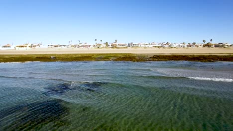 Aerial,-a-low-angle-pass-across-the-ocean-waves-and-the-beaches-at-Puerto-Peñasco,-Rocky-Point,-Gulf-of-California,-Mexico