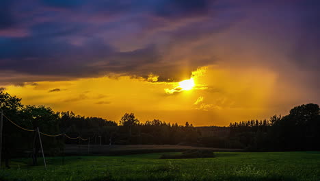 luz dorada de las corrientes de sol por debajo pasando nubes grises de lluvias, luz naranja a través de la pradera del bosque