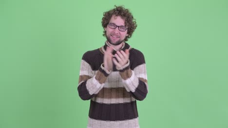 un joven guapo con barba y cabello rizado.