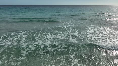 Fliegen-Sie-Zurück-über-Strand-Mit-Wellen-In-Cala-Millor,-Mallorca,-Spanien