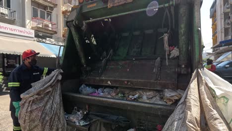 worker managing waste in a garbage truck