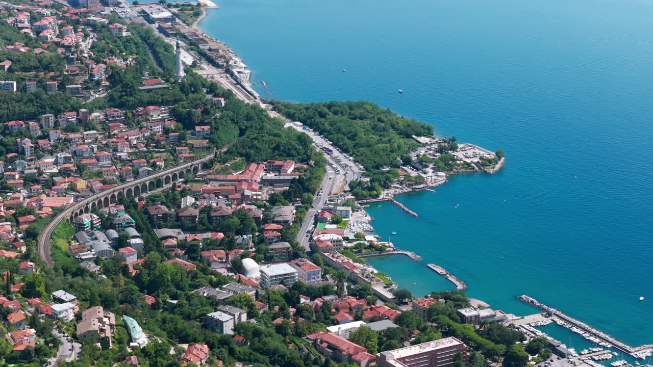 Panorama aereo con drone del paesaggio urbano di Trieste, zona residenziale, viadotto ferroviario e Mar Adriatico, Italia.