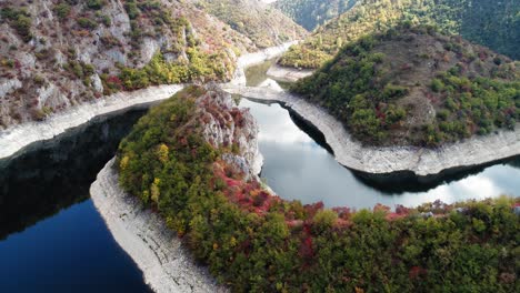 drone pull away shot of dark blue river and beautiful foliage, kanyon uvac, serbia, slow motion