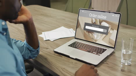 hombre afroamericano usando una computadora portátil, compras en línea de productos de belleza, cámara lenta