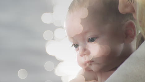animación de puntos de luz sobre una madre caucásica sosteniendo a su bebé