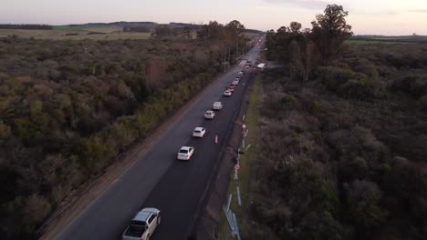 line of cars in a row queuing on rural rectilinear highway of uruguay